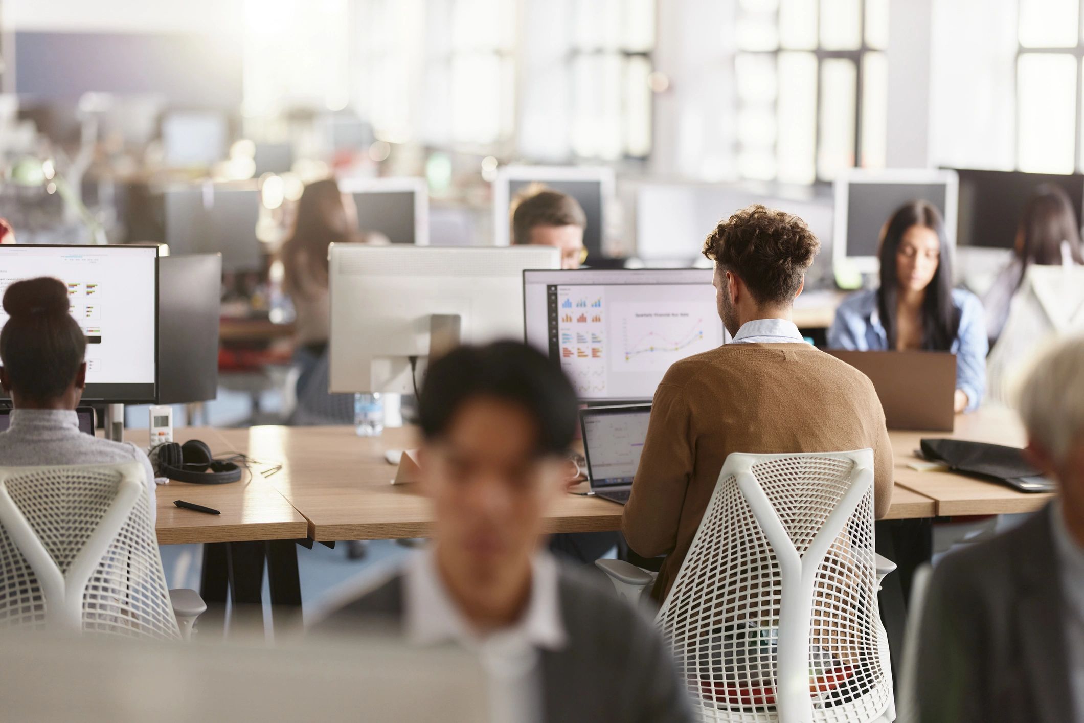 Profesionales trabajando en oficina con equipos de cómputo