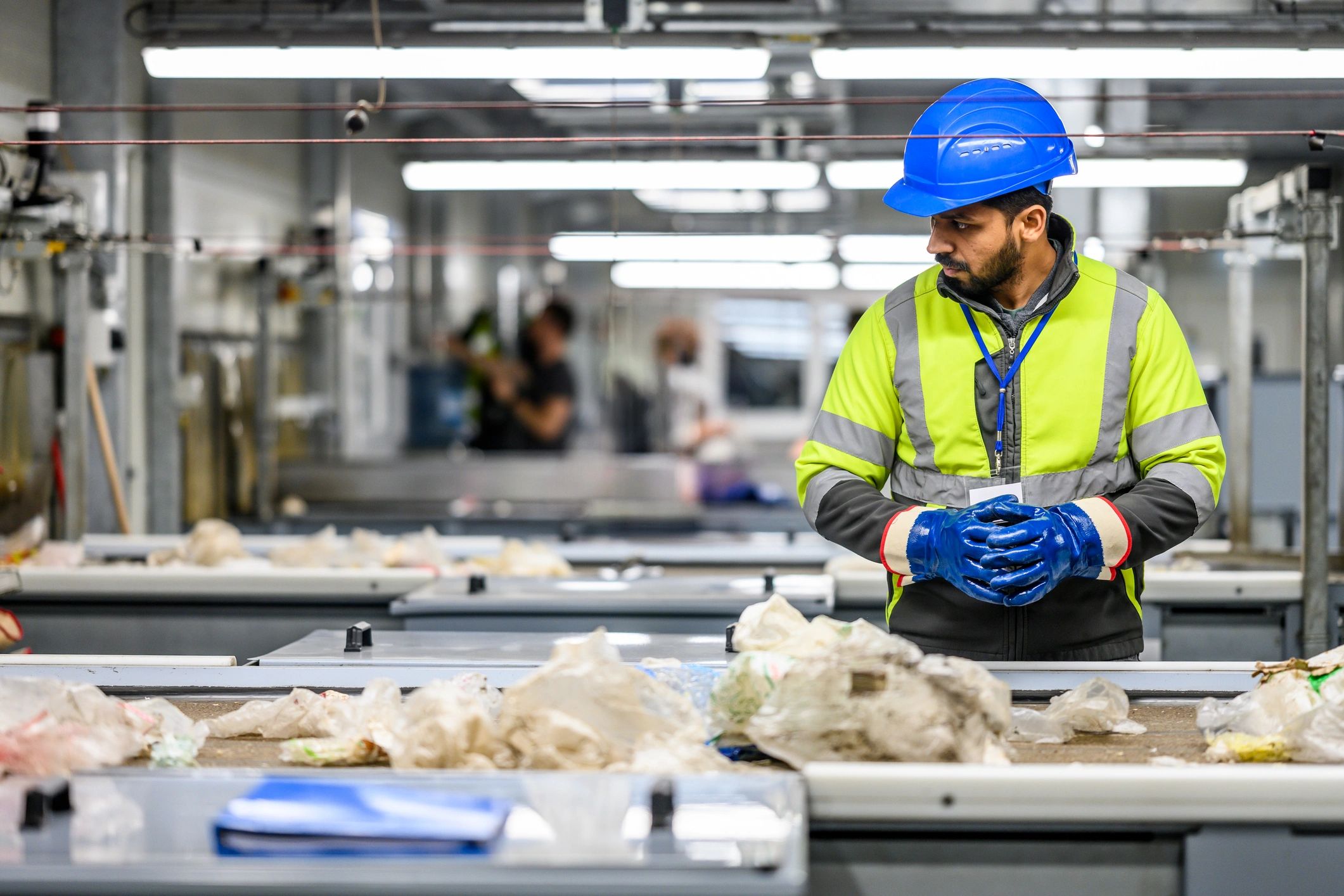 Trabajador inspeccionando materiales en un centro de reciclaje